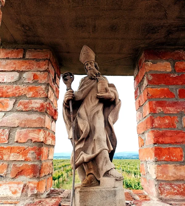 Socha svätca v murovanom výklenku s výhľadom do vinice