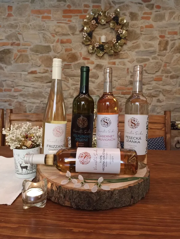 Fľaše vín Vinárstva Sivko na stole s adventným vencom